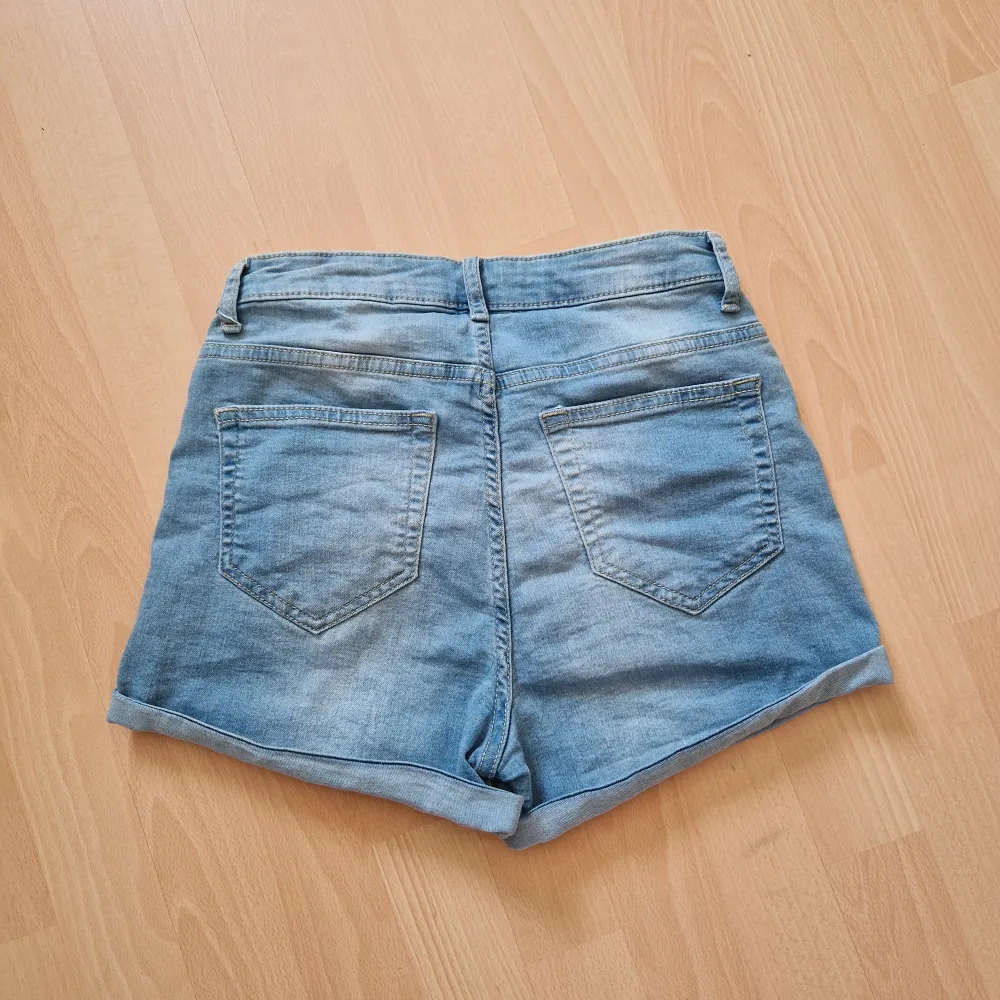 Blåa, högmidjade jeansshorts. . Shorts.
