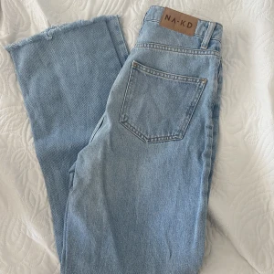 Blåa raka jeans - Jeans med raka ben i ljusblå tvätt från NAKD. I storlek 32 men passar även 34. Passar mig i längden som är ca 158 cm. Endast använda 1 gång. 150kr + frakt