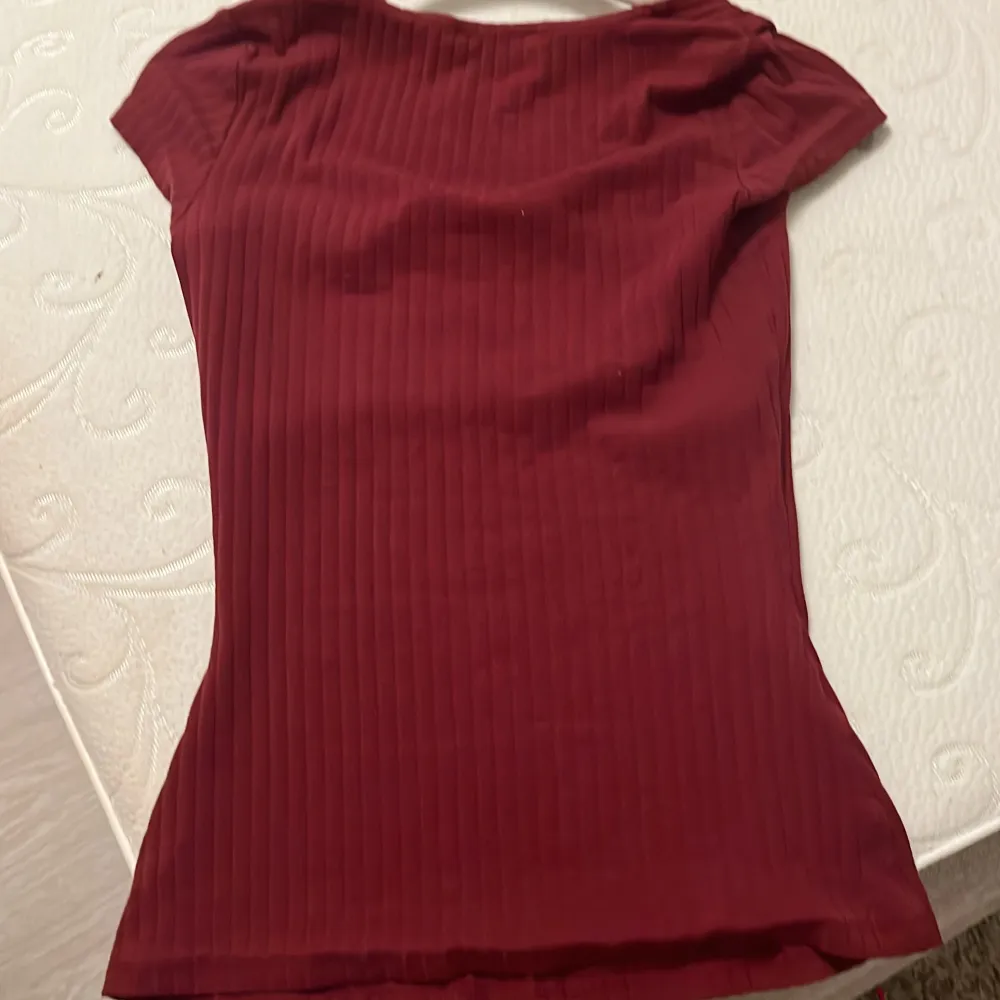 En vinröd tröja med urringning, korta armar, är knappt använd och är fin till vad som helst. Köpt för 300kr men säljer för 250kr. T-shirts.