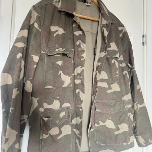 Grön jacka - Tunnare jacka i militärmönster köpt på hm för massor med år sen. Kommer ej till användning. 