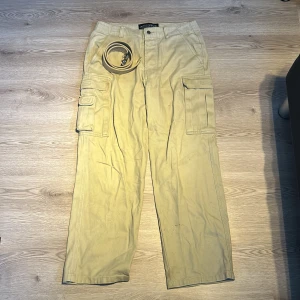 Beige cargo pants - Begie kargopants från maui-wowie. Dem är straigthlegg och sitter riktigt snyggt. Har inte använts mycket alls. Har ett matchande bälte som man kan få med om man vill
