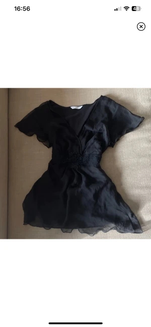 Topp - En super söt tröja i (”mesh”) och virkade detaljer vid midjan. V- ringad så det ger brösten fina former. 