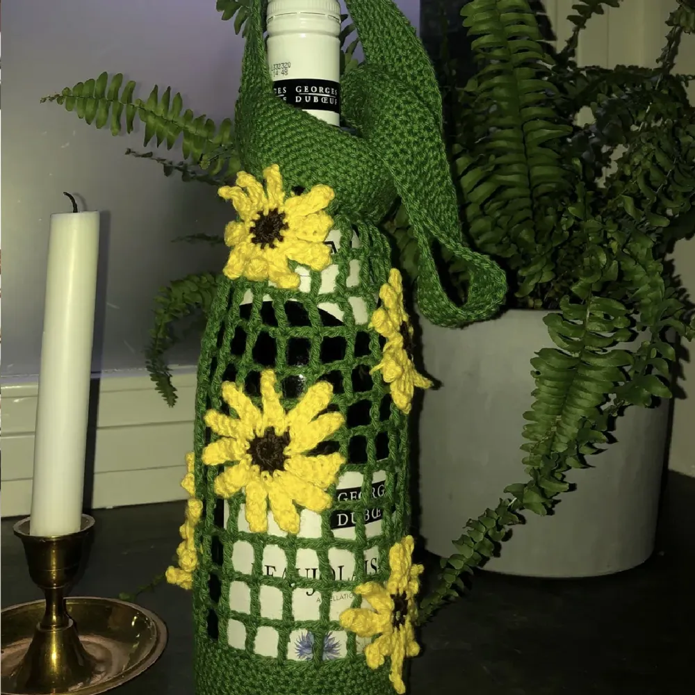 Virkad vinväska med blommor på! Vinväskan kan få i annan modell ( se tidigare inlägg) eller detta rutnät. Både vinväskorna och blommorna kan fås i vilka färger man vill. Väskorna virkas på beställning! 🌸🌼🌸🌼🌸🌼. Väskor.