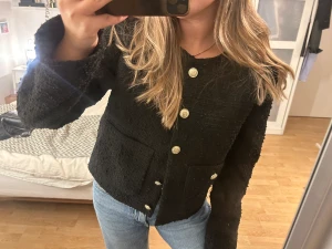 Stickad jacka  - kofta/höstjacka i svart med guldiga knappar i ny skick