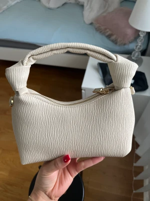 Mango väska  - Helt ny väska från Mango. Använd endast en gång, därav i perfekt skick. Går att använda som Axelremsväska också då den har en guldig längre kedja inuti. 
