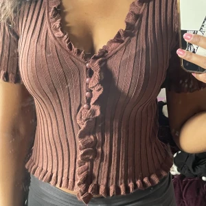 Brun kortärmad topp - Jättesöt brun kortärmad top med knappar och detaljer, använts ca 2 gånger och är i god skick!