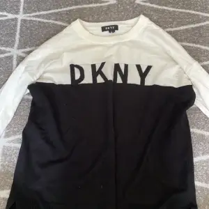 En tröja från DKNY i ganska bra skick men en liten fläck och foundation vid halsen men ska gå att få bort.
