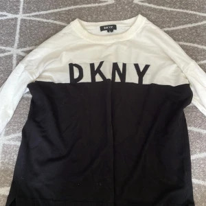 DKNY tröja - En tröja från DKNY i ganska bra skick men en liten fläck och foundation vid halsen men ska gå att få bort.