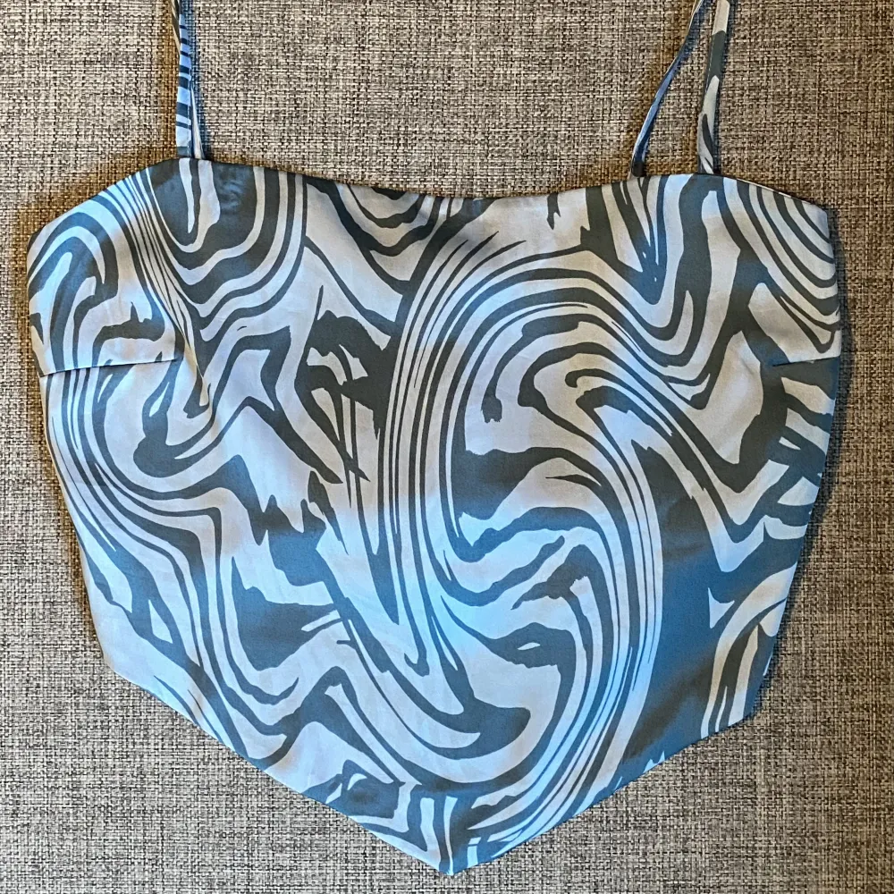 Silk material. Adjustable straps. Stretchy section in the back (expandable). Good condition.. Toppar.