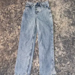 Highwaist jeans med slits längst smalbenet som detalj. Även knappar för att knäppa igen istället för en dragkedja.