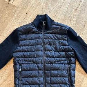 Moncler cardigan (svart) - Hej jag säljer min moncler cardigan! Pga att jag inte känner en stor nytta av den samt att jag behöver pengarna. Produkten är köpt på plick men är äkthets kollad på moncler butiken i sthlm (NK) hör gärna av er om ni undrar ngt!😊😁