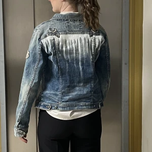 Jeansjacka odd Molly (saint blank design) - Odd Molly jeansjacka med perfekt passform och kvalitet. Köpt second hand som företaget sedan gjort sitt eget tryck på ryggen. Passar både man och kvinna, strl xs/s i dam beroende på hur man vill den ska sitta. 