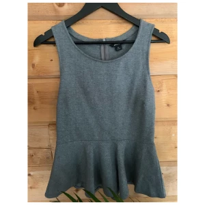 Grå peplumtopp - Grå topp med peplum. Sparsamt använd. Storlek M.