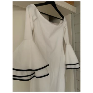 Vit off-shoulder klänning med trumpetärmar - Vit åtsittande klänning med vackra trumpetärmar. Off-shoulder. Storlek 40, aldrig använd. 