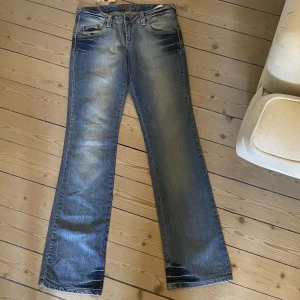 Lågmidjade jeans - Såå snygga lågmidjade jeans med cool tvätt och unika fickor. Helt i nyskick med lappen kvar. Modellen är rak och lätt utsvängd nedtill. Storlek w27 l34, som en xs-s fast långa i benen. Mått: midja 38 cm tvärs över, innerben 82 cm. Skriv vid funderingar❤️