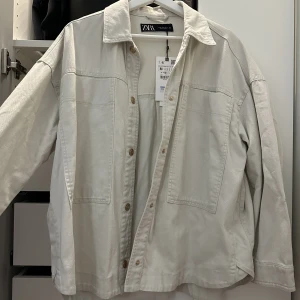 Jeansjacka Zara - Vit jeansjacka från Zara, aldrig använd prislappen är kvar. Storlek M
