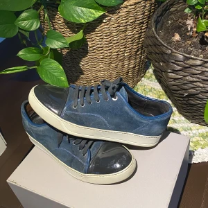Lanvin Patent Cap Toe Sneakers Navy Blue - Hej, säljer ett par Lanvin Cap Toe Sneakers i marinblå färg med svart Toebox. De är i bra skick och kan fixas till ännu bättre om man försöker. Storlek 8 vilket motsvarar 42/43. Nypris runt 4000kr. Priset är inte hugget i sten. Hör av dig vid intresse!