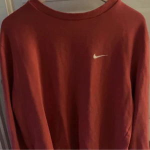 Röd nike tröja - Röd nike tröja med vintagestil. Bilden är lånad från tidigare ägare men fråga gärna om egna. Står ingen storlek men sitter ganska oversize på mig som är xs/s och 164cm.