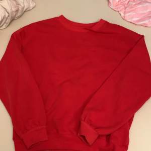 En röd sweater. Köpt på H&M.  Bra skick. Har inga tags vid kragen, men en vid magen. Har några knappt synliga blekare fläckar på magen
