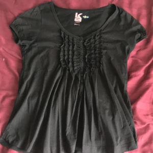 Svart tröja  - En svart tröja med ”volang” fram, den är i strl large men kan nog sys om. Säljs pga att den inte kommer till användning :)