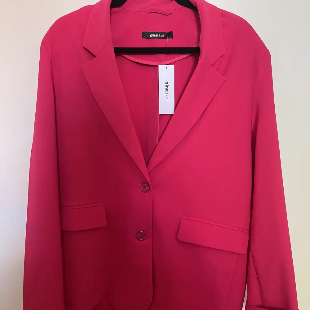 Helt oanvänd oversized blazer från Gina Tricot. Inköpt i butik för 799kr och har sedan dess endast hängt i garderoben. Har slits längst ned i ryggen. . Kostymer.