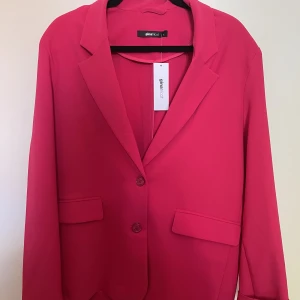 Oanvänd oversized rosa blazer från Gina - Helt oanvänd oversized blazer från Gina Tricot. Inköpt i butik för 799kr och har sedan dess endast hängt i garderoben. Har slits längst ned i ryggen. 