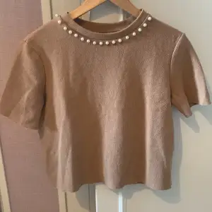 Jätte gullig tröja ifrån Zara i färg jätte ljus brun med pärlor vid halsen. Den sitter jätte fin på och är stretchig. Säljer då den inte passar och kommer inte till användning. 