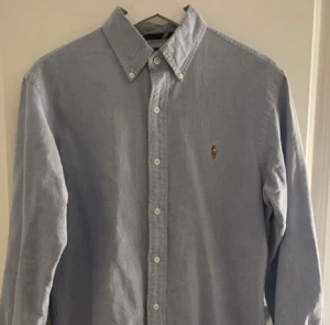 Ralph Lauren skjorta - Ljusblå raffe skjorta storlek M. Väldigt bra skick, för liten för mig. Pris 300kr