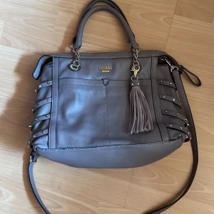 Axel och handväska - Jätte fin grå/ beun skin väska från guess, kan användas som axel och handväska. Köparen står för frakten och så kan priset diskuteras