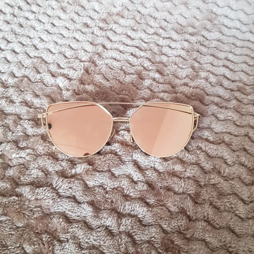 Solglasögon med guldiga bågar och glas i roséguld. Cateye modell. Accessoarer.