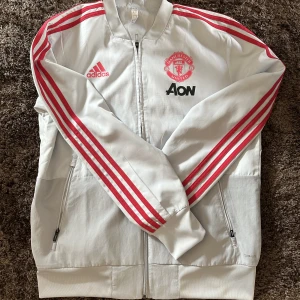 Manchester United träningströja - Säljer nu min snygga Manchester United träningsjacka då jag aldrig använt den. Den är köpt i Manchester för 800 kr. Vid funderingar eller mer bilder är det bara att skriva!