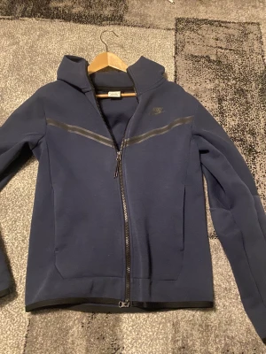 Nike tröja  - Säljer nu min mörk blåa Nike tech tröja den är lite blekare eftersom den har gott i tvättmaskinen ett par gånger men den är i bra skick ändå