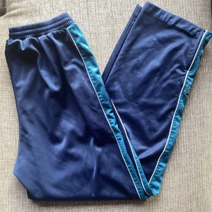 blå trackpants - lågmidjade trackpants som är inköpta här på plick! står att storleken är xl men passar mig som vanligtvis har s då den går att knyta i midjan. innberbenslängden är ca 71cm och midjan är ca 75cm men stretchig :-)