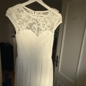 Vit klänning med spets och öppen rygg  - Klänning från Nelly, endast testad. Superfin studentklänning eller midsommarklänning! 