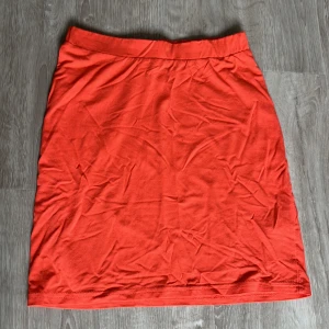 Minikjol i korall  - Jättefin kjol i korall, har en liten svart fläck mitt på men inget som stör