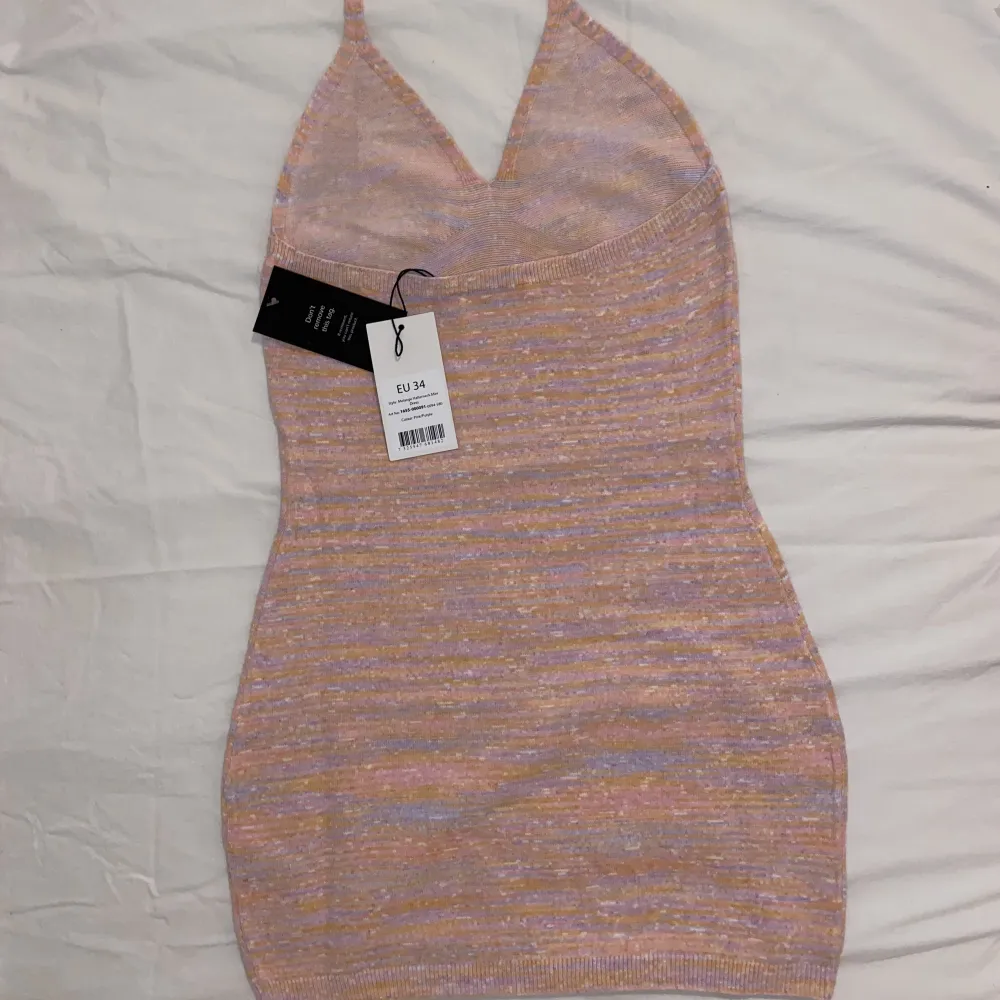 En miniklänning i halterneckmodell från nakd i en rosa färg med tutch av ljusorange. Storlek 34. Orginalpris: 469kr. Säljer då den var för liten.. Klänningar.