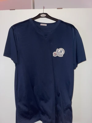 Moncler Double Logo T-Shirt - Säljer min Moncler Double Logo T-Shirt storlek XL (är lite i storleken så sitter som en L). Ny pris är 2840kr. Använd 1 gång så den är i nyskick. Säljer för 1000kr