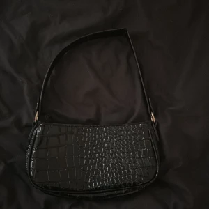 Svart handväska  - Säljer en jätte fin svart handväska med gulddetaljer, den är varsamt använd. 