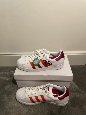 Adidas Superstar (W) -  Superstar HER studio London (W). Tjejskor storlek 40.5 Helt nya och oanvända.