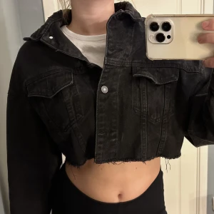 Kort jeansjacka - Jeansjacka med slitningar nertill som slutar över naveln