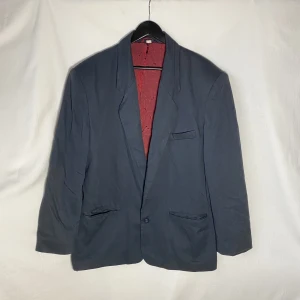 Mörkblå kavaj - Tunnare kavaj med rött foder i nylon. Längd: 76cm Ärm: 63cm   Skicka DM vid frågor. ☆．。･