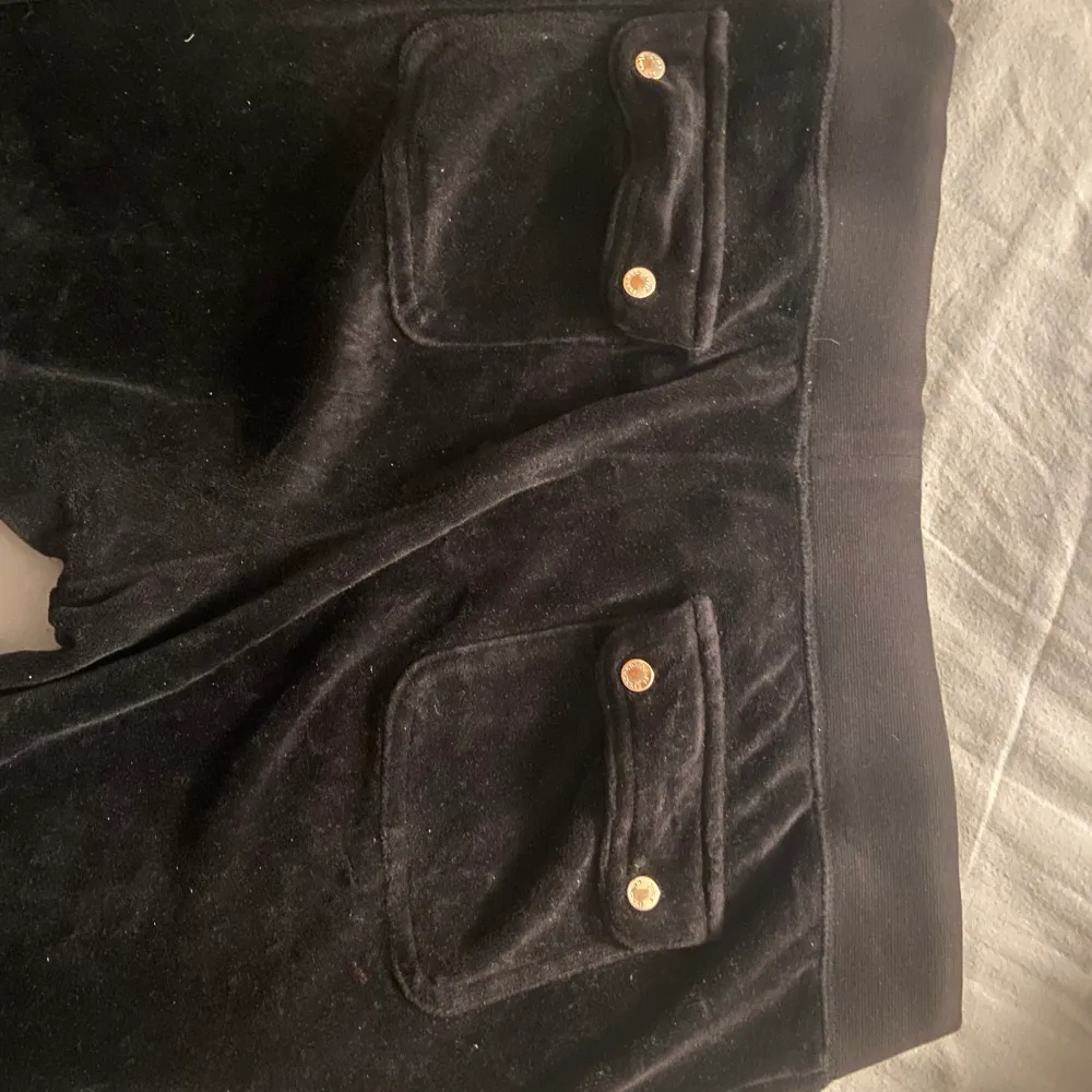 Svarta juicy couture byxor i en äldre modell. Dem är lågmidjade och i storlek small. Defekt på knapparna där bak då lite av den silvriga färgen försvunnit, annars bra skick. . Jeans & Byxor.