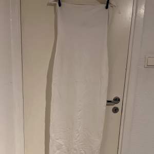 Figursydd vit klänning utan band med slits där bak från NA-KD. I utmärkt skick då jag bara använt den 2 gånger innan.