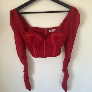 Oh Polly topp - Röd croptop med korsett från Oh Polly, armarna i mesh-tyg