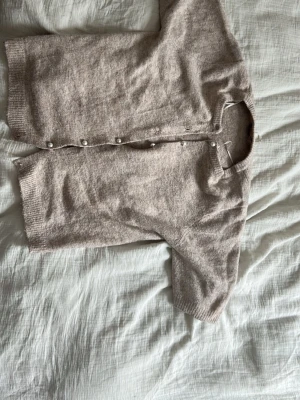 Beige kofta med pärlknappar från 157 - Mysig beige kofta från 157 i storlek S. Saknar knapp längst ner 