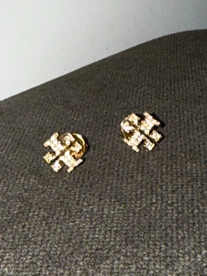 Tory burch örhängen  - Säljer mina tory burch örhängen, kommer i dust bag och själva kasetten som den säljs med. Köpt på NK. HAR INGET KVITTO PGA FÅTT I PRESENT. Örhängena är i rostfritt stål så bra kvalité, alla stenar är kvar 