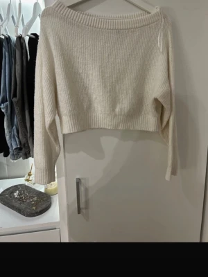 Vit croppad stickad tröja H&M Divided - Superfin vit croppad stickad tröja från H&M Divided. Tröjan har bred ribbad kant vid halsen och ärmarna är långa. Perfekt till jeans eller kjol för en chill och snygg look.