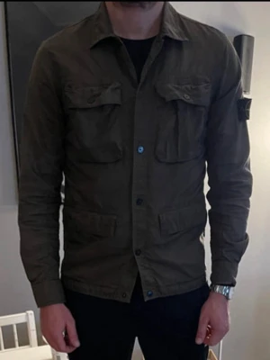STONE ISLAND - Overshirt - Säljer en olivgrön overshirt från Stone Island med klassisk patch på vänster ärm. Jackan är i mycket bra skick och passar perfekt över en hoodie. Nypris ca 6500