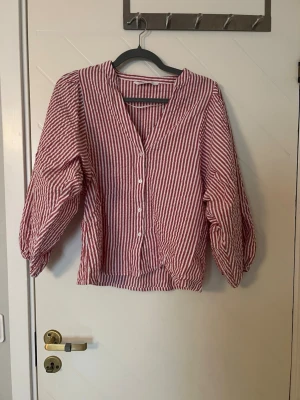 Randig blus - Jag säljer en randig blus med trekvarts samt ballong ärm. Jag säljer denna då den inte används längre. Skjortan är använd varsamt och köpt för 300kr men säljer för 100kr. 
