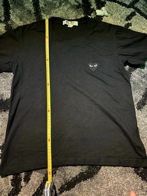 Svart Comme des Garçons Play t-shirt - Svart t-shirt från Comme des Garçons Play med det ikoniska hjärta med ögon broderat på bröstet. Klassisk rund hals och korta ärmar. Tillverkad i mjuk bomull för skön känsla och clean look.